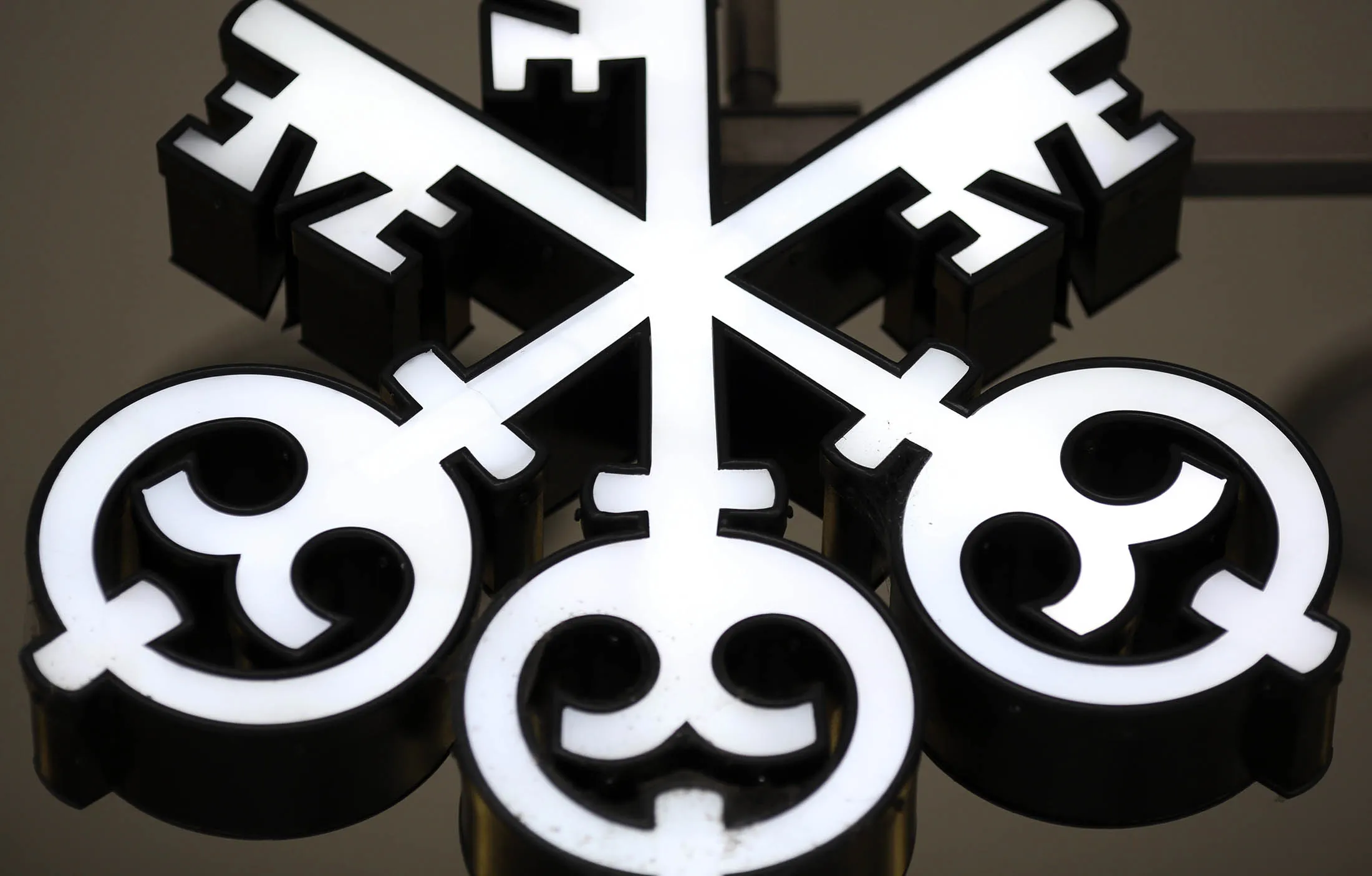 A company logo hangs outside the entrance of UBS Group headquarters in Zurich.
