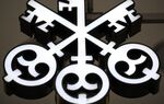 A company logo hangs outside the entrance of UBS Group headquarters in Zurich.
