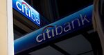 The silhouette of a pedestrian holding a mobile device is seen walking past a Citigroup Inc. bank branch in San Francisco.