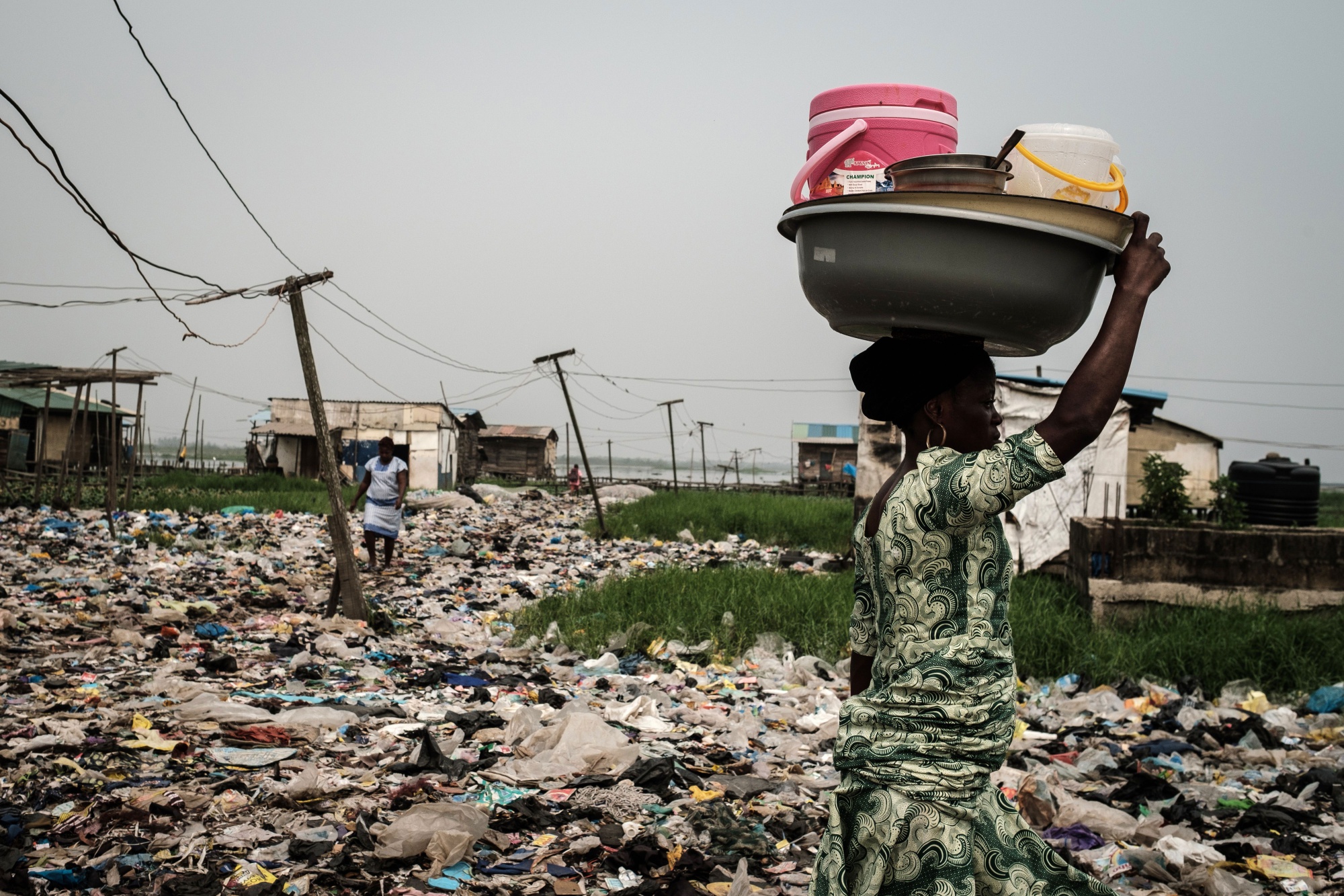 A woman walks on plastic waste in Lagos.