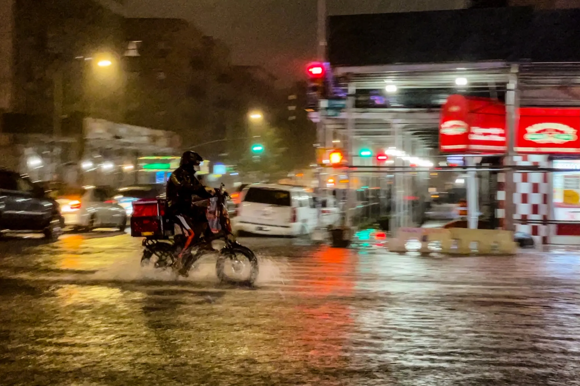 A delivery worker makes their way in the rainfall from Hurricane Ida in the Bronx borough of New York City.