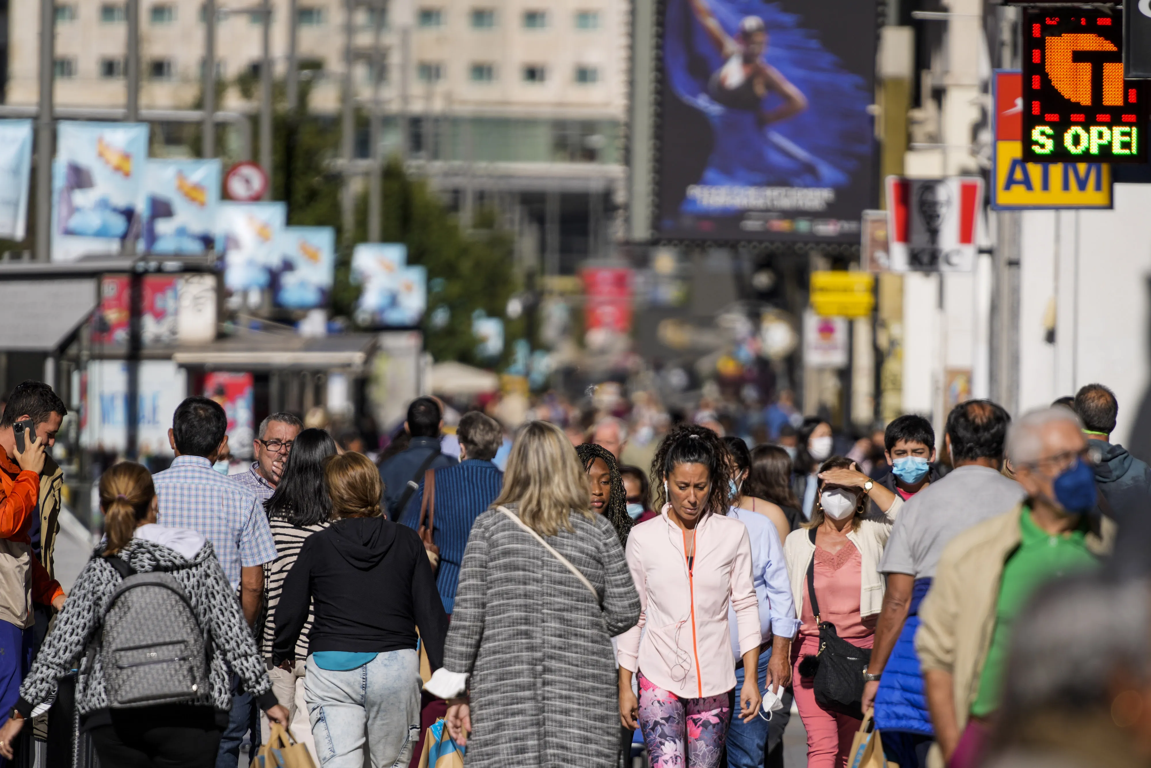 Shoppers walk along the Gran Via in Madrid.