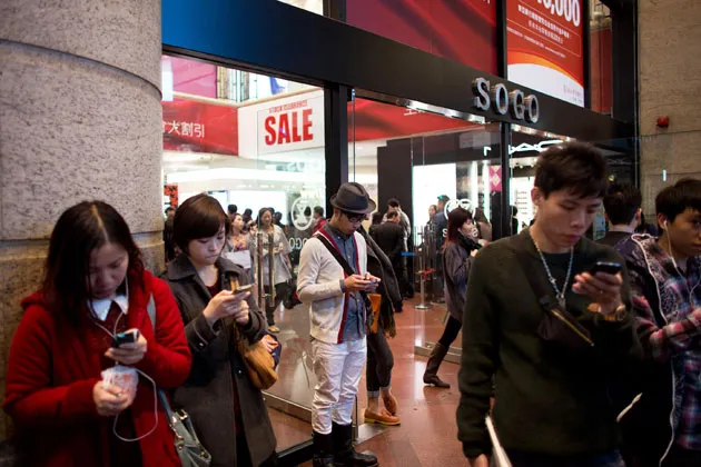 Pedestrians use their mobile phones outside the Sogo department store in the Causeway Bay district of Hong Kong