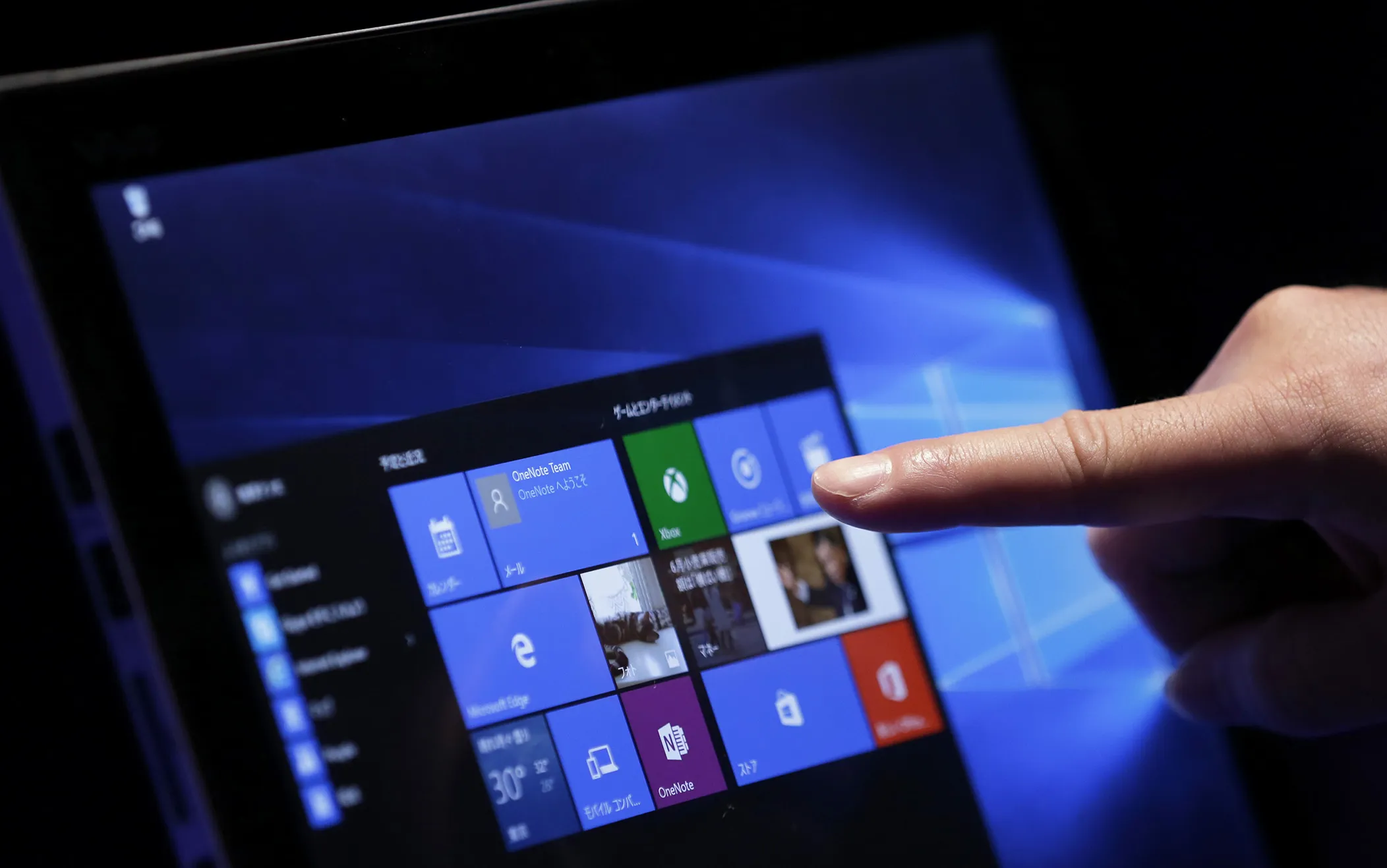 A visitor tries out Microsoft's Windows 10 operating system on a tablet device during an event in Tokyo.

