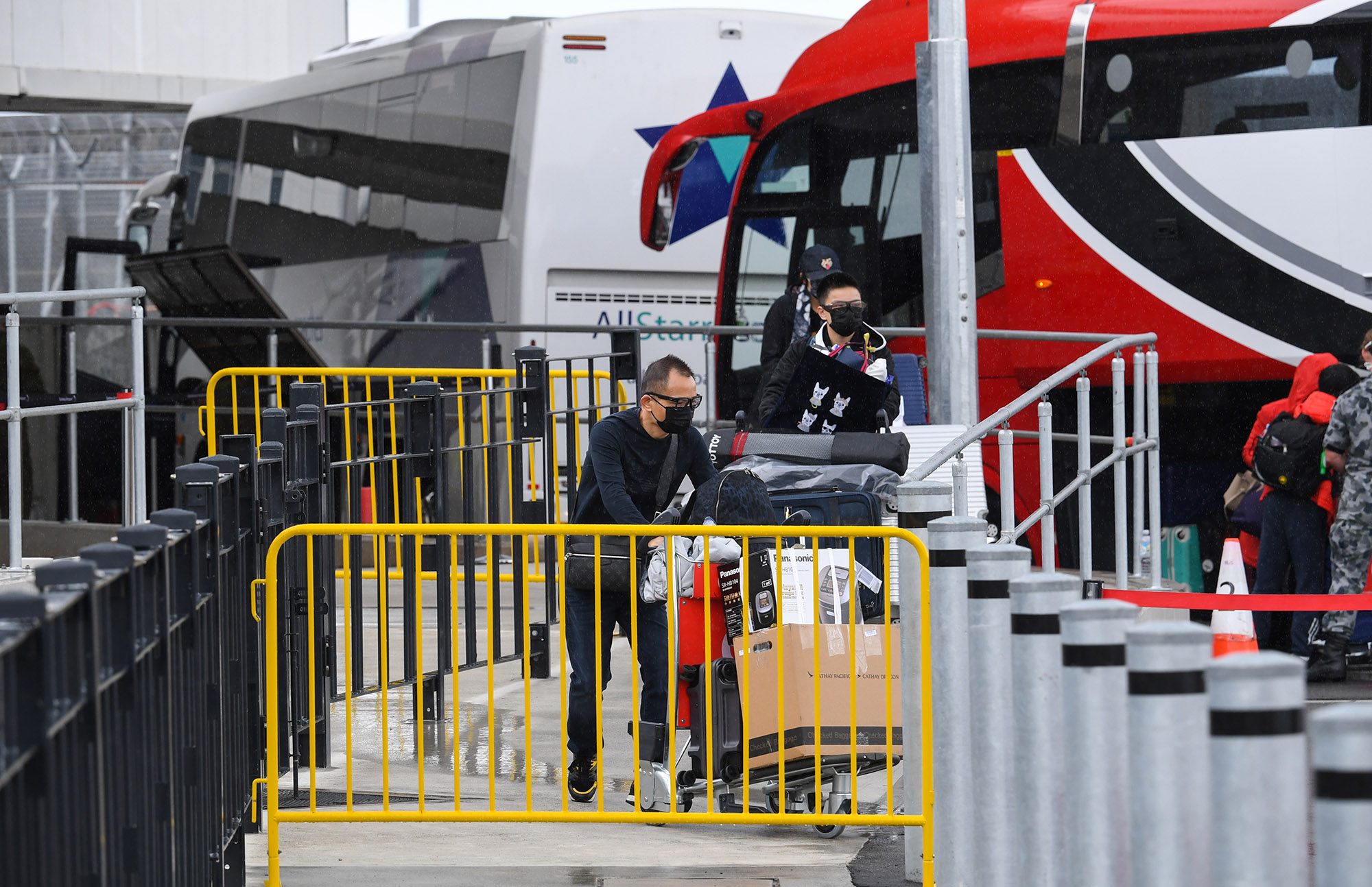 Passengers walk to a hotel quarantine bus at Sydney International Airport.