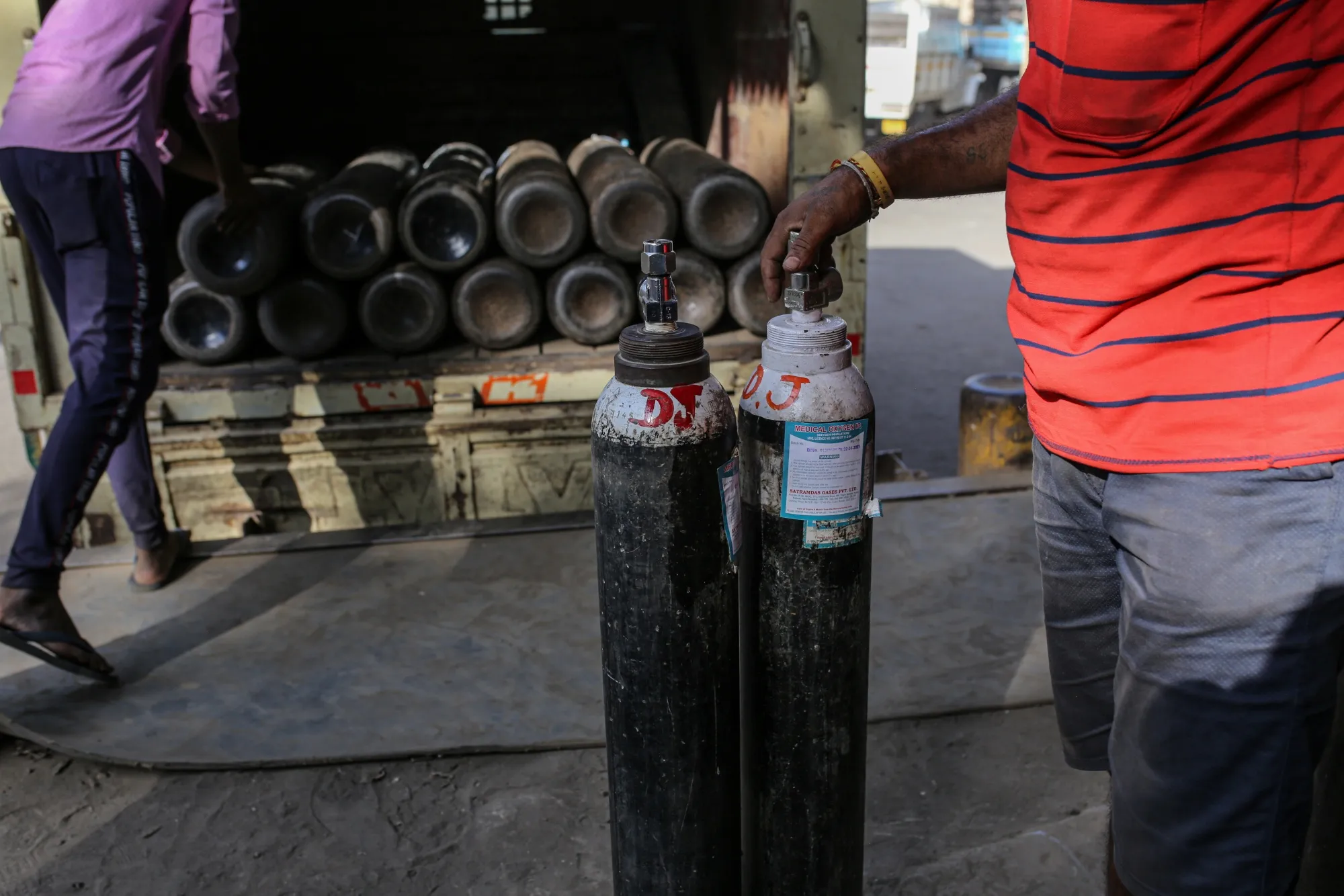 Workers load refilled oxygen tanks into a vehicle at a refill station in Navi Mumbai on April 22.