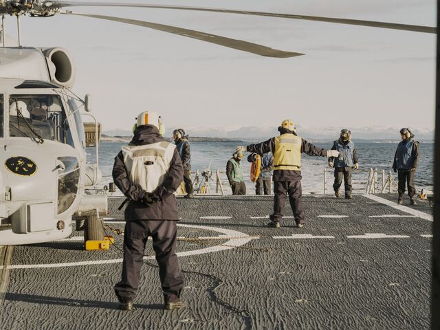 Crew prepare a helicopter to launch from the deck of the Almirante Juan de Borbon.