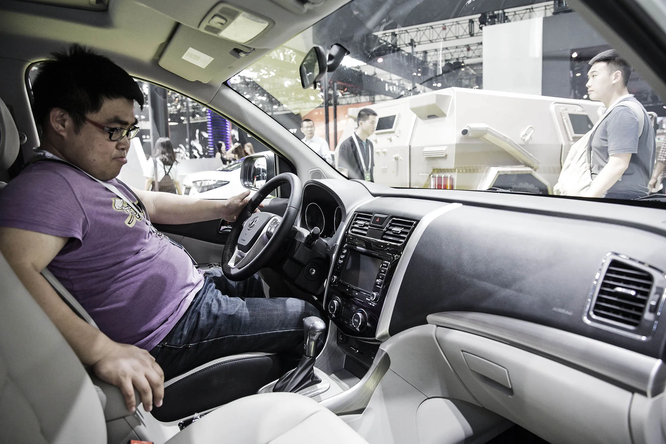 A visitor sits in the driver's seat of a Dongfeng S500 electric car at the Beijing International Automotive Exhibition. New car smell is deemed unpleasant in China, where formaldehyde pollution of interior air have worried people.
