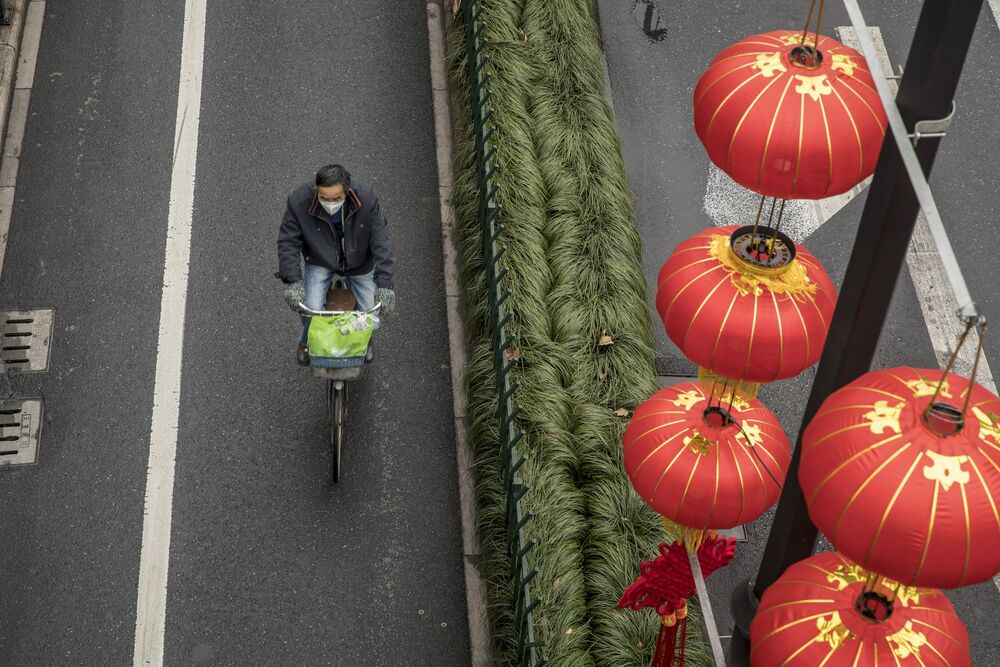 A cyclist wearing a face mask passes decorative lanterns in Hangzhou, China, on Tuesday, Feb. 11, 2020. 
