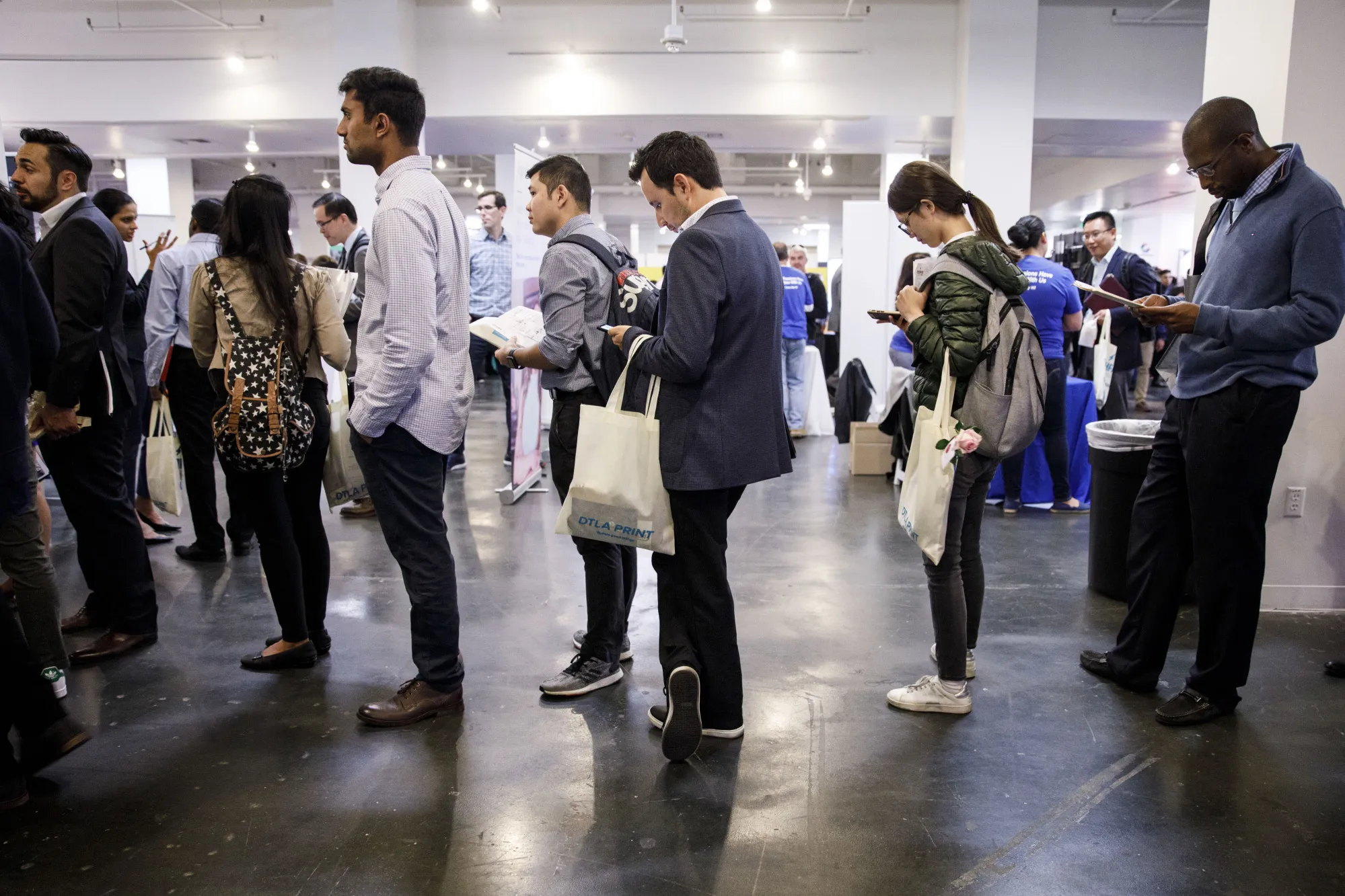 Job seekers wait in line to speak with a representative during a career fair in Los Angeles.