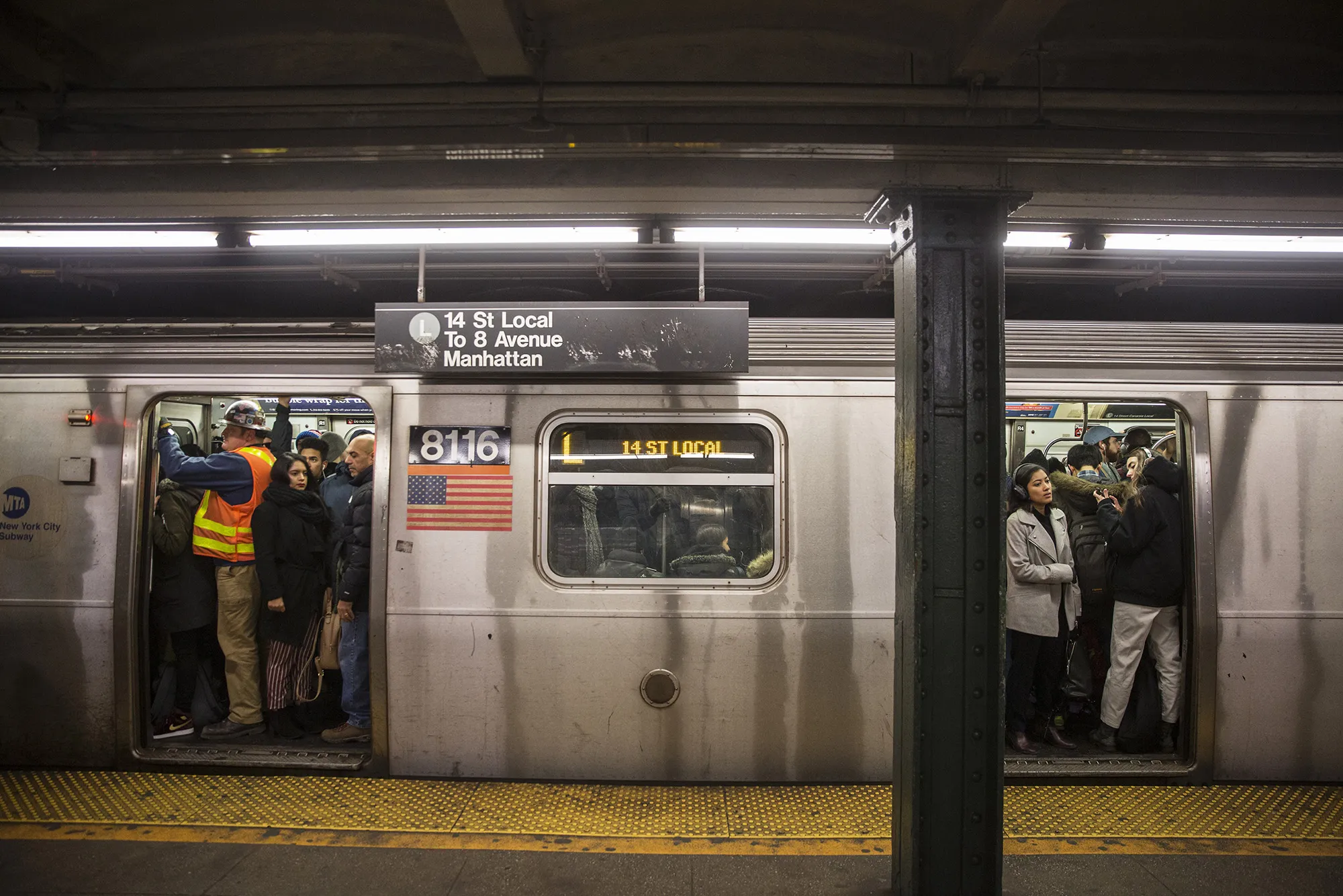Commuters stand in a crowded L train subway car at the Bedford Avenue station in the Brooklyn borough of New York.