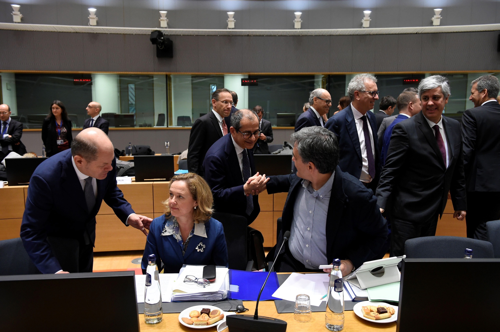 Giovanni Tria, center, greets&nbsp;Euclid Tsakalotos at the&nbsp;Eurogroup meeting&nbsp;on Dec. 3.