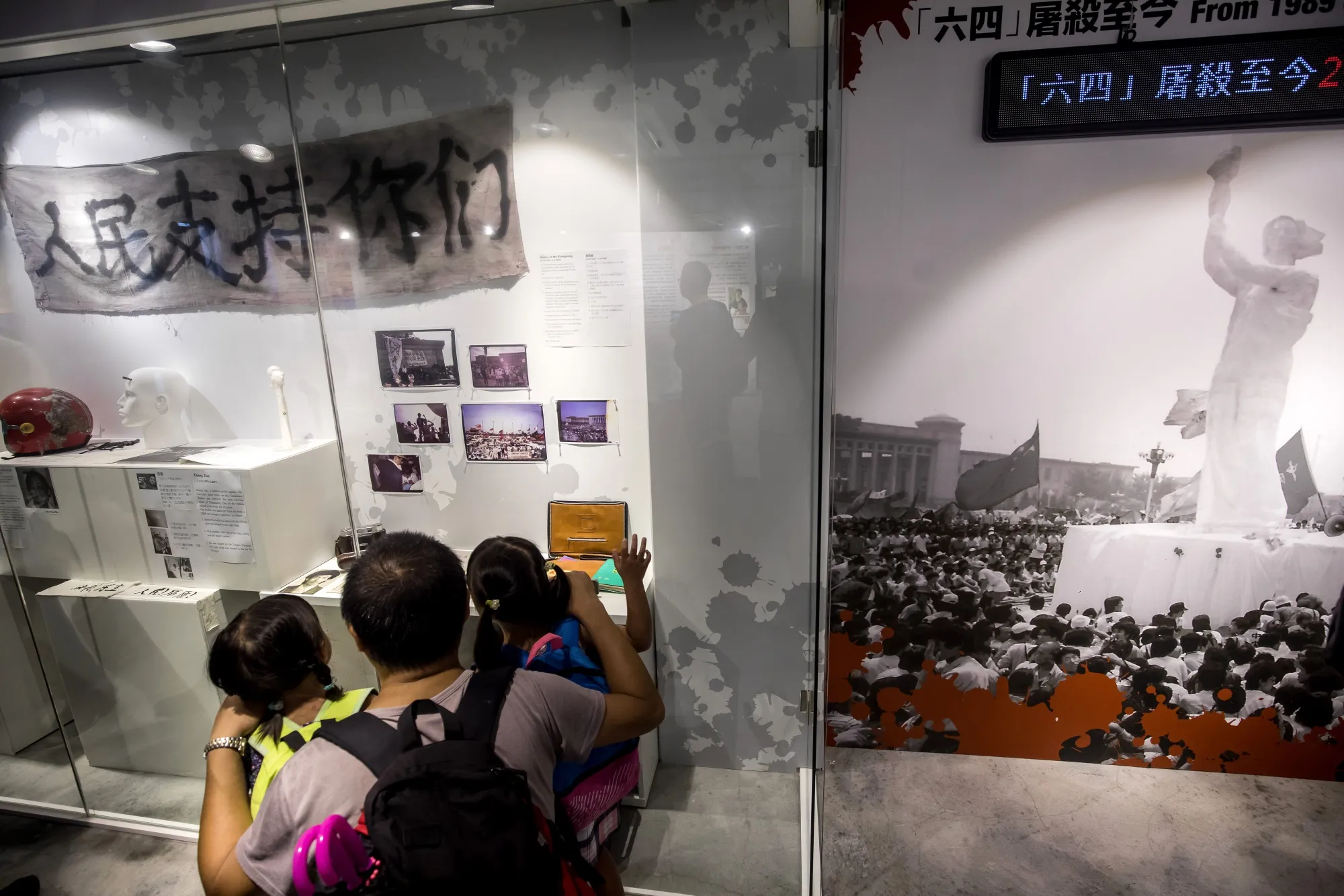 Visitors look at artifacts recovered from the scenes of the 1989 Tiananmen Square protests at the June 4th Museum.