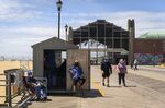 People wearing protective masks sit on the boardwalk in Asbury Park, New Jersey&nbsp;on&nbsp;May 22.&nbsp;
