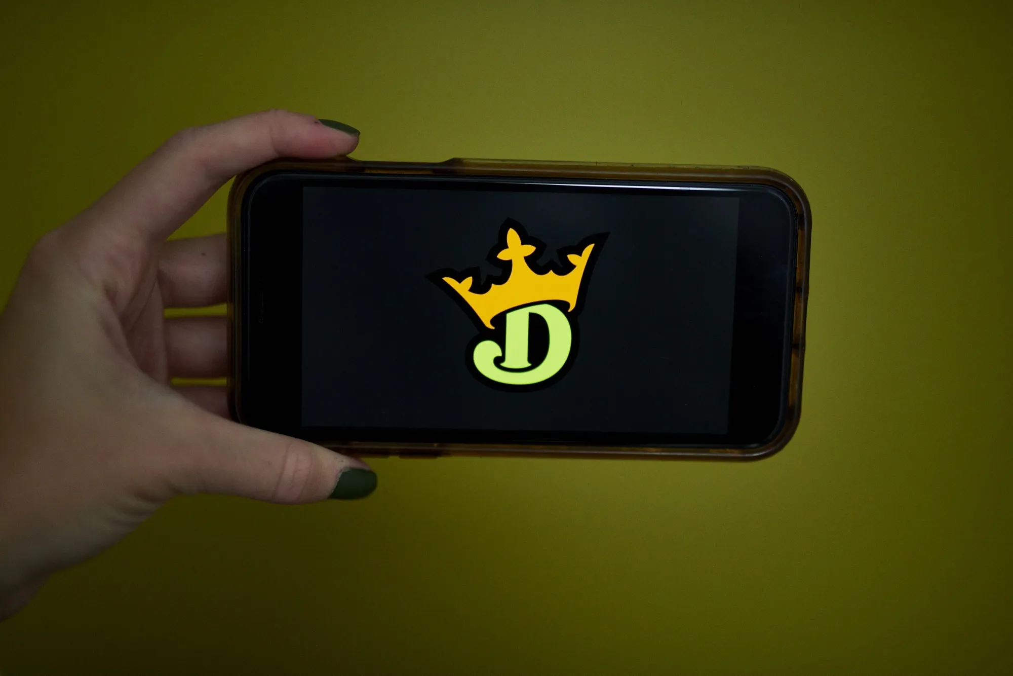 The logo for DraftKings is displayed on a smartphone in an arranged photograph taken in Little Falls, New Jersey, U.S., on Wednesday, Oct. 7, 2020.&nbsp;