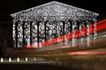 Cars pass the national assembly in Paris, where a projection of French artist JR is displayed as part of the 2015 climate talks.