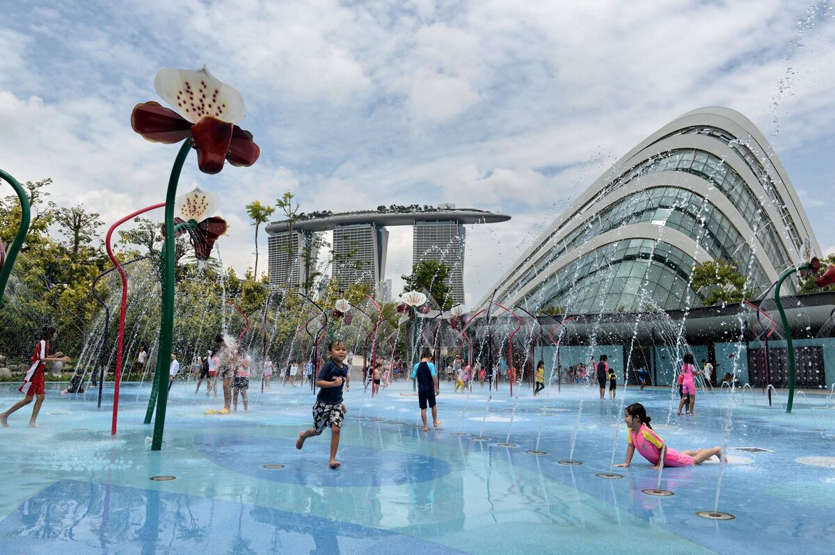 Children splash in a playground with the Marina Bay Sands hotel in the background