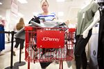 A customer pushes a shopping cart inside a J.C. Penney Co. store in Peoria, Illinois.