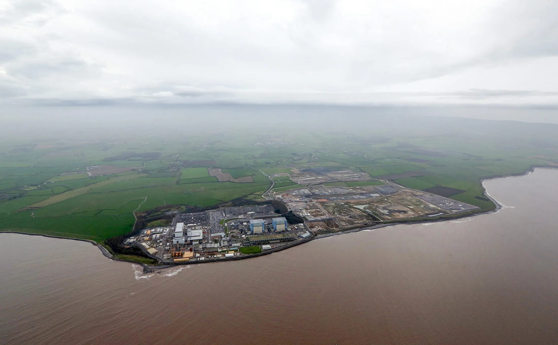 Hinkley Point B nuclear power station, operated by Electricite de France SA's (EDF), left, stands near to groundworks for Hinkley Point C near Bridgwater.
