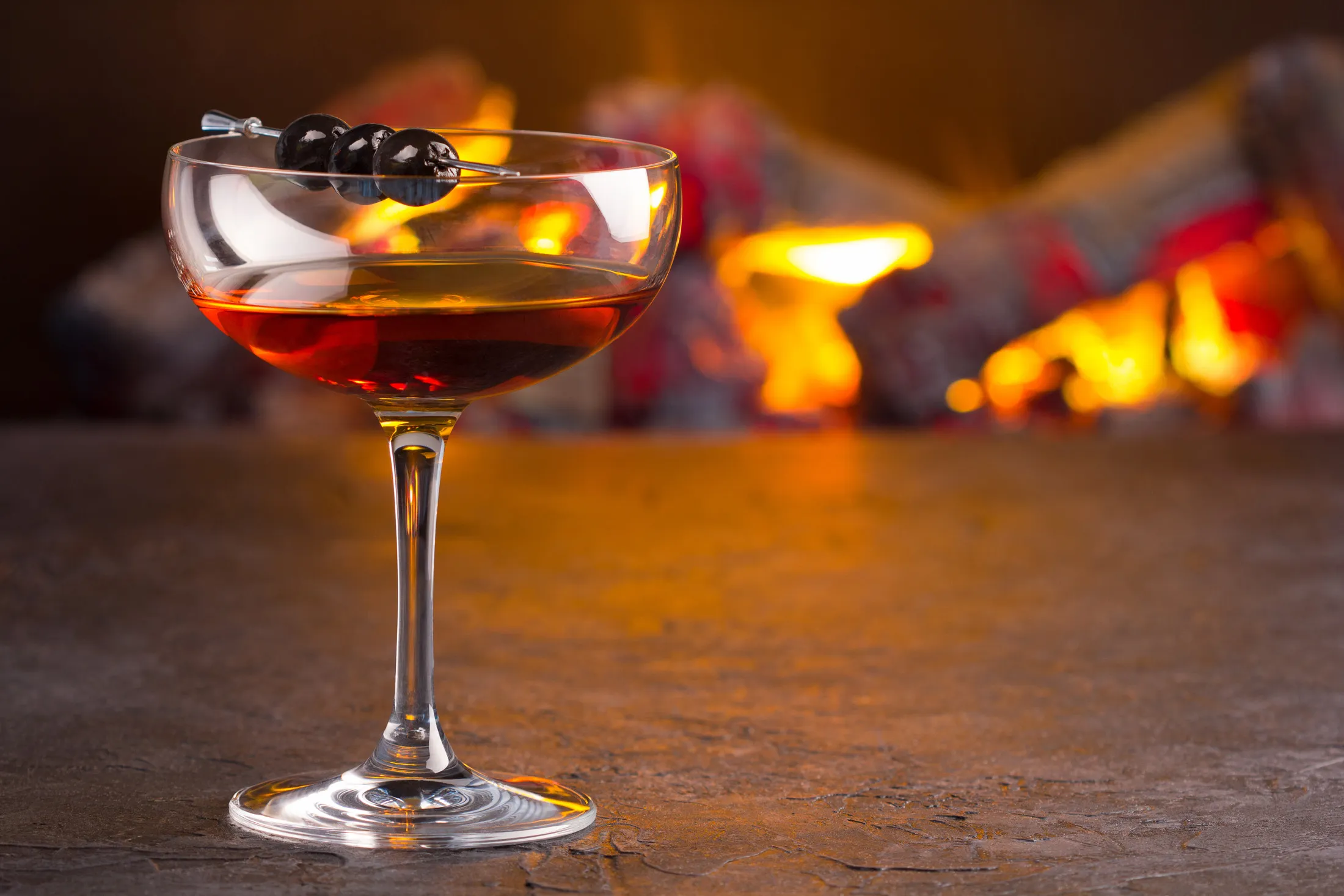 A classic Manhattan cocktail, nicely backlit by a wood fire, will make you feel like other people are less necessary.