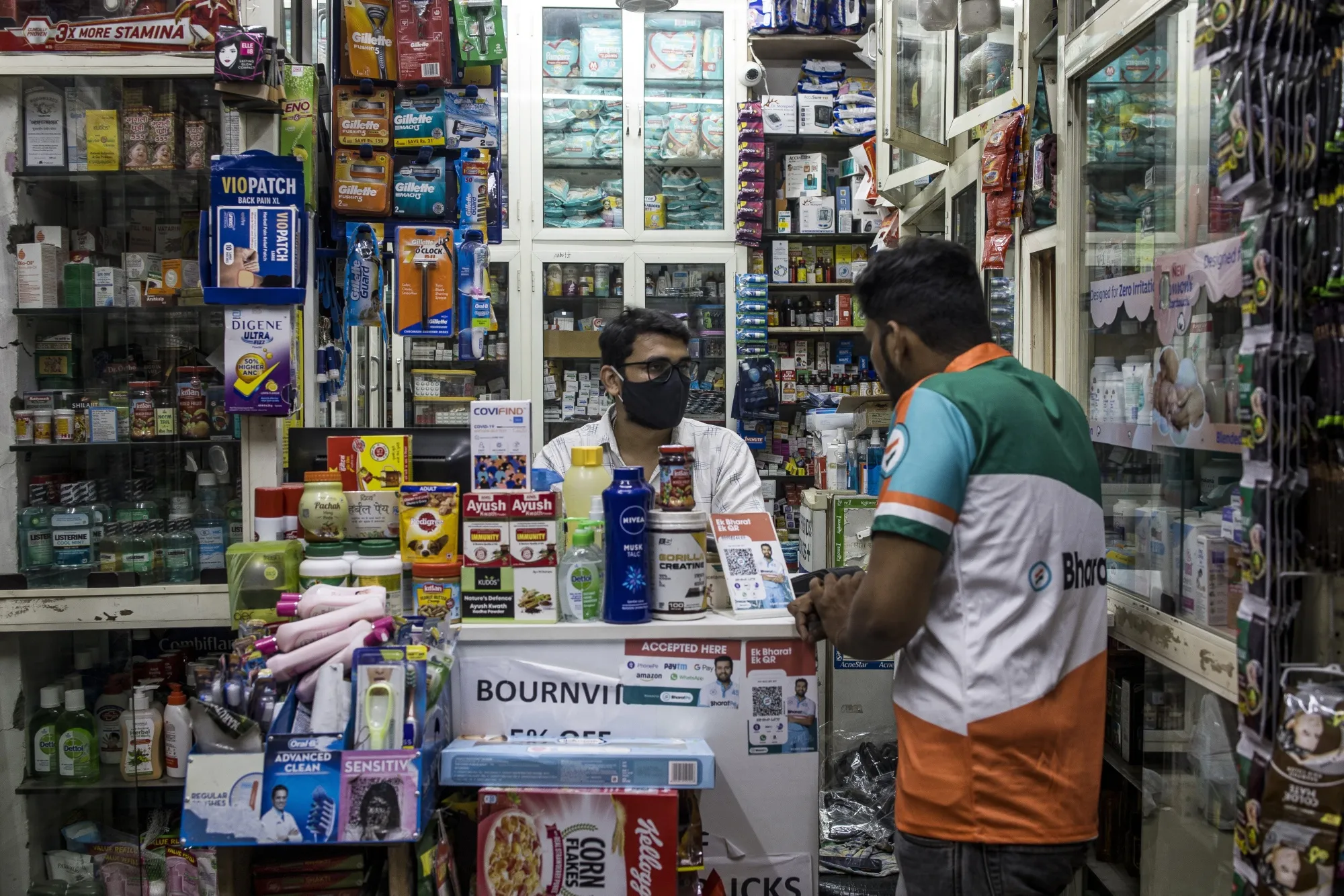 A BharatPe employee discusses the digital payment system with a store owner in New Delhi.