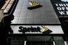 A pedestrian passes in front of a Sprint Corp. store.