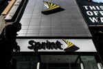 A pedestrian passes in front of a Sprint Corp. store.