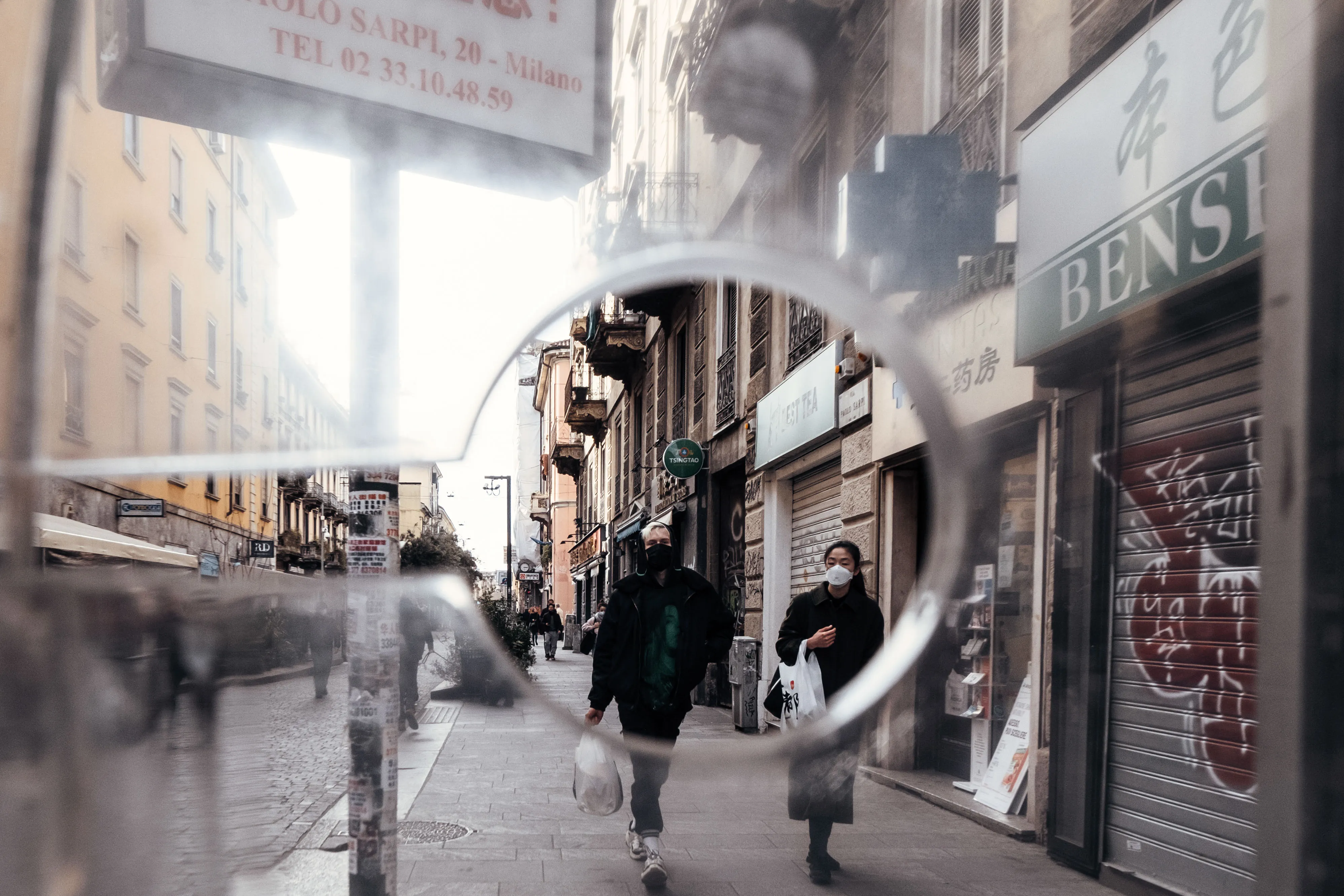Pedestrians wearing protective face masks walk through a district of Milan, Italy.