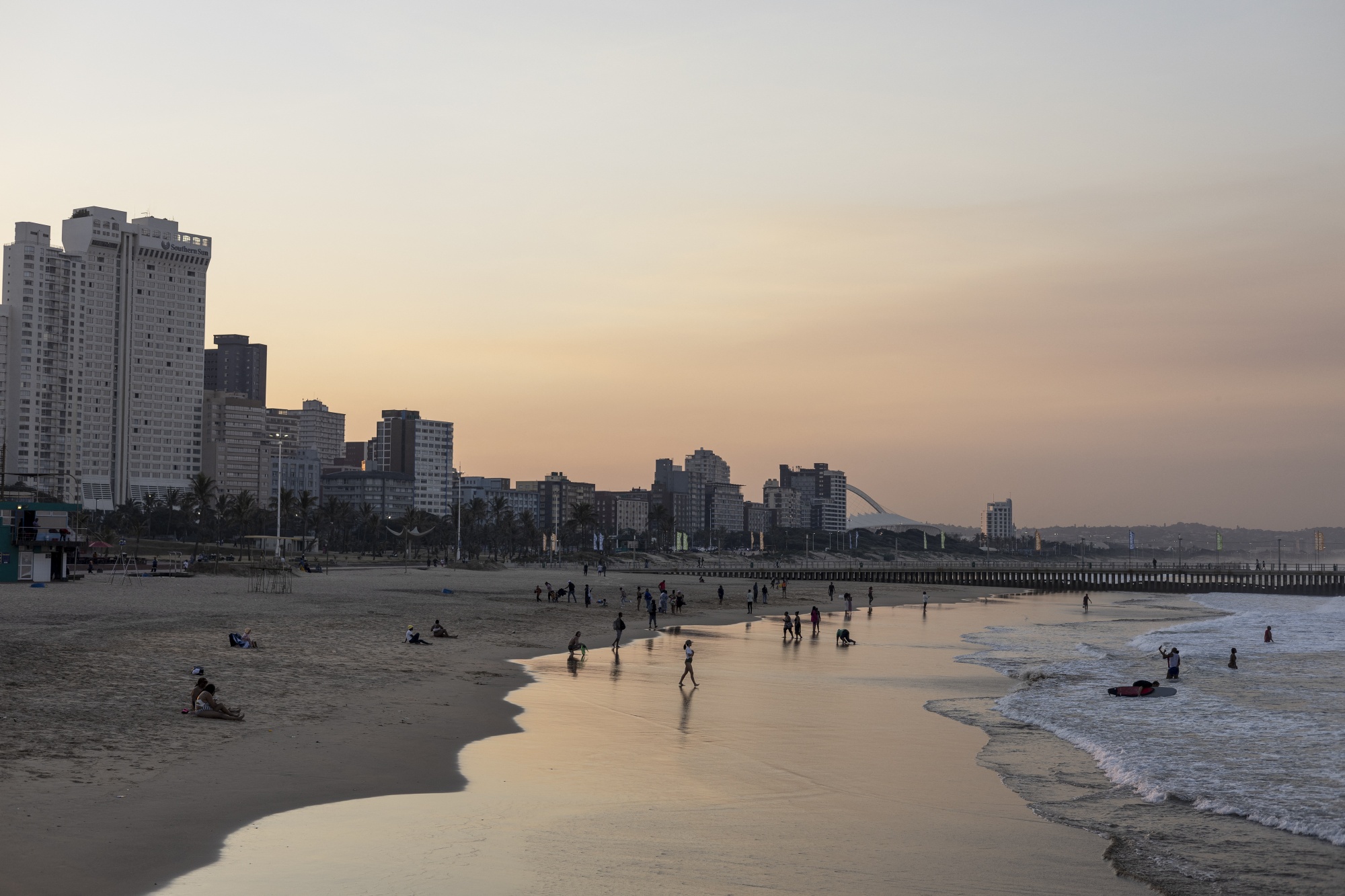 Beachgoers at sunset in Durban, South Africa. Photographer: Wikus de Wet/AFP/Getty Images
