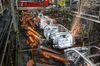 Robotic machines weld together the frames of vehicles during production at the General Motors Co. assembly plant in Arlington, Texas.
