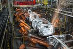Robotic machines weld together the frames of vehicles during production at the General Motors Co. assembly plant in Arlington, Texas.