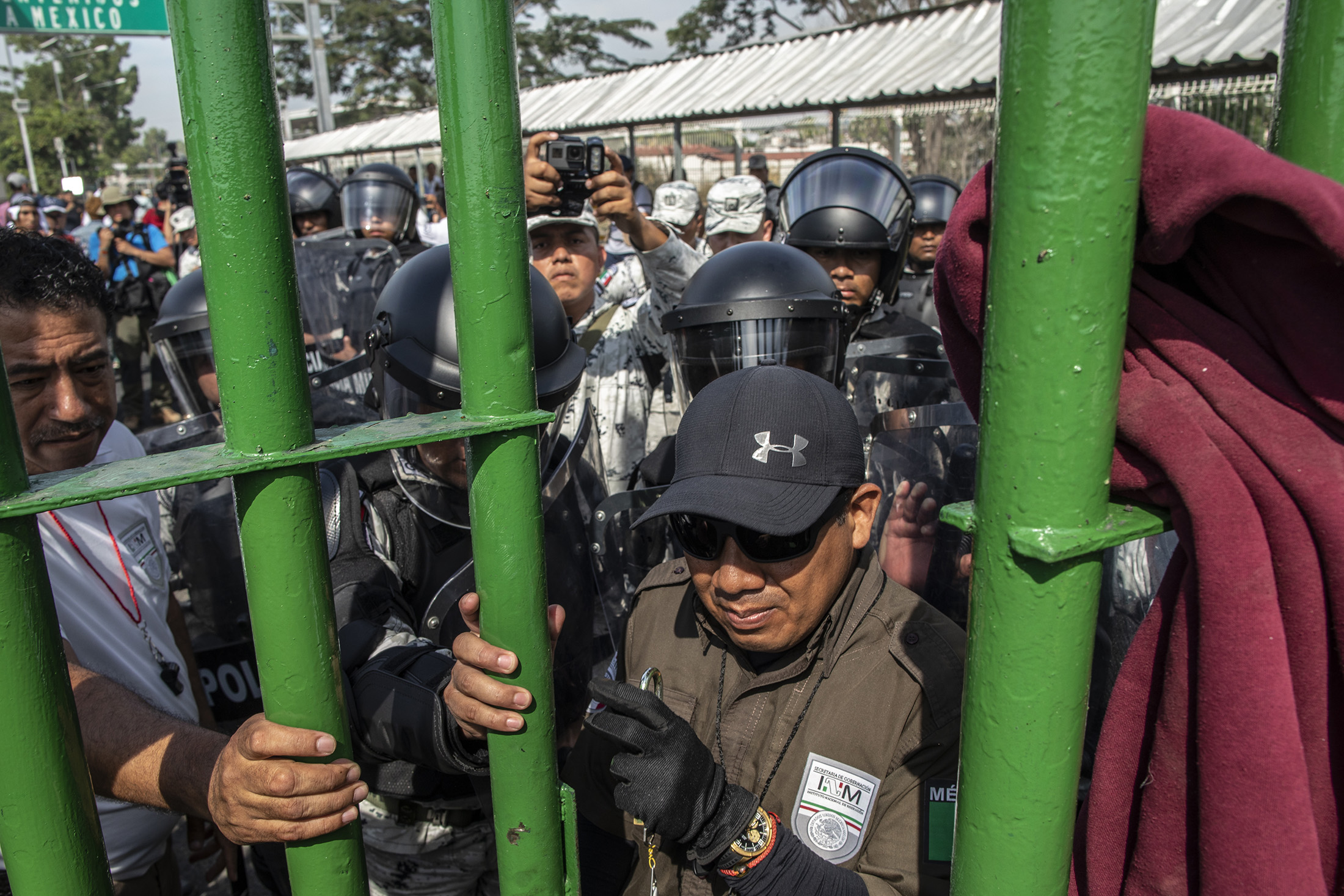 Mexican National Guard members stands behind a closed fence to prevent Central American migrant from crossing into Mexico&nbsp;on Jan. 18.