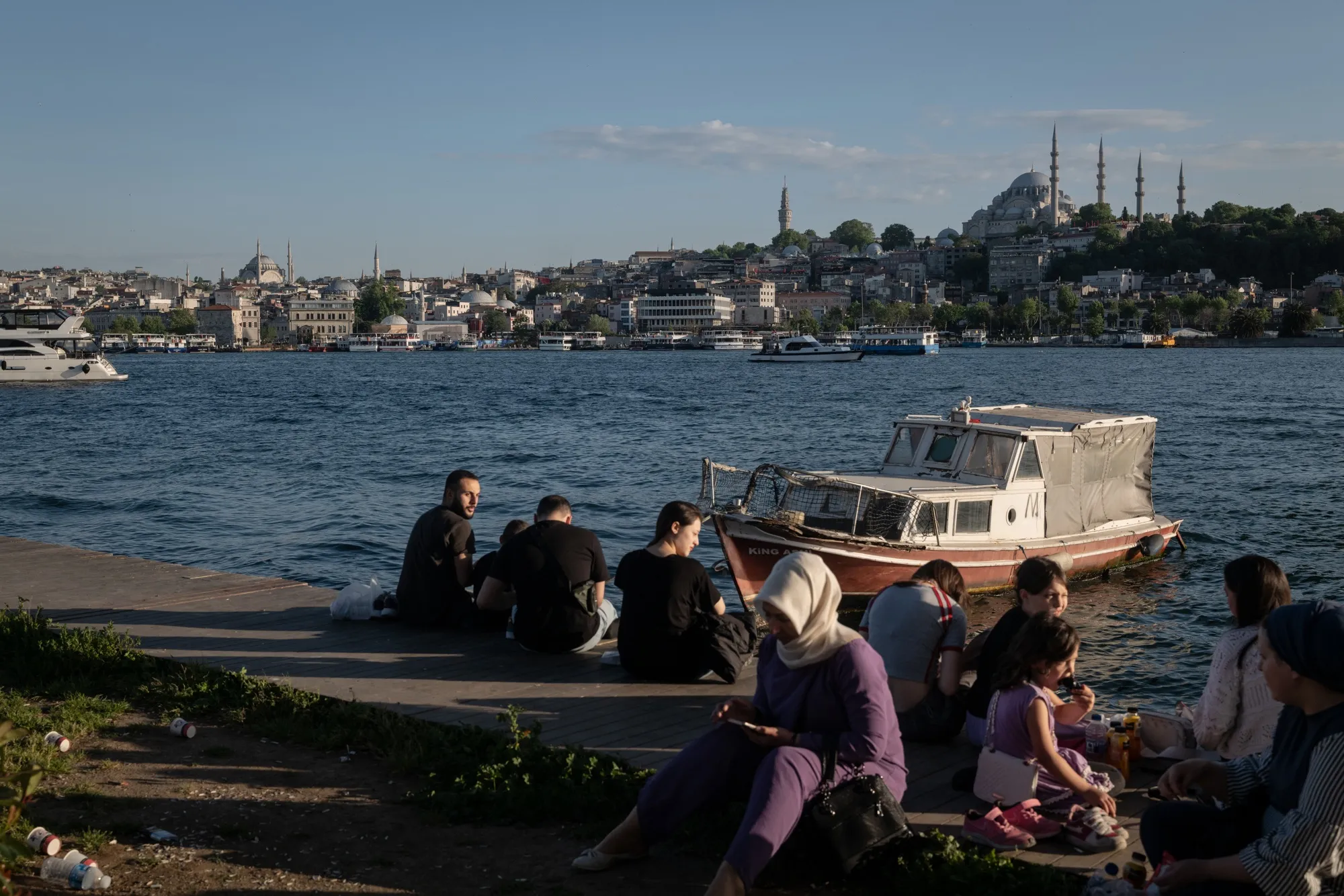 Visitors picnic beside the waterway on the Golden Horn in Istanbul, Turkey.