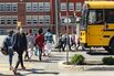 Kids in line crossing street to get on school bus.