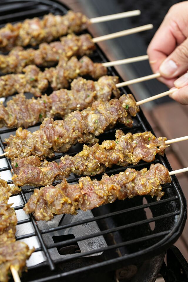 Uncooked beef skewers on grill