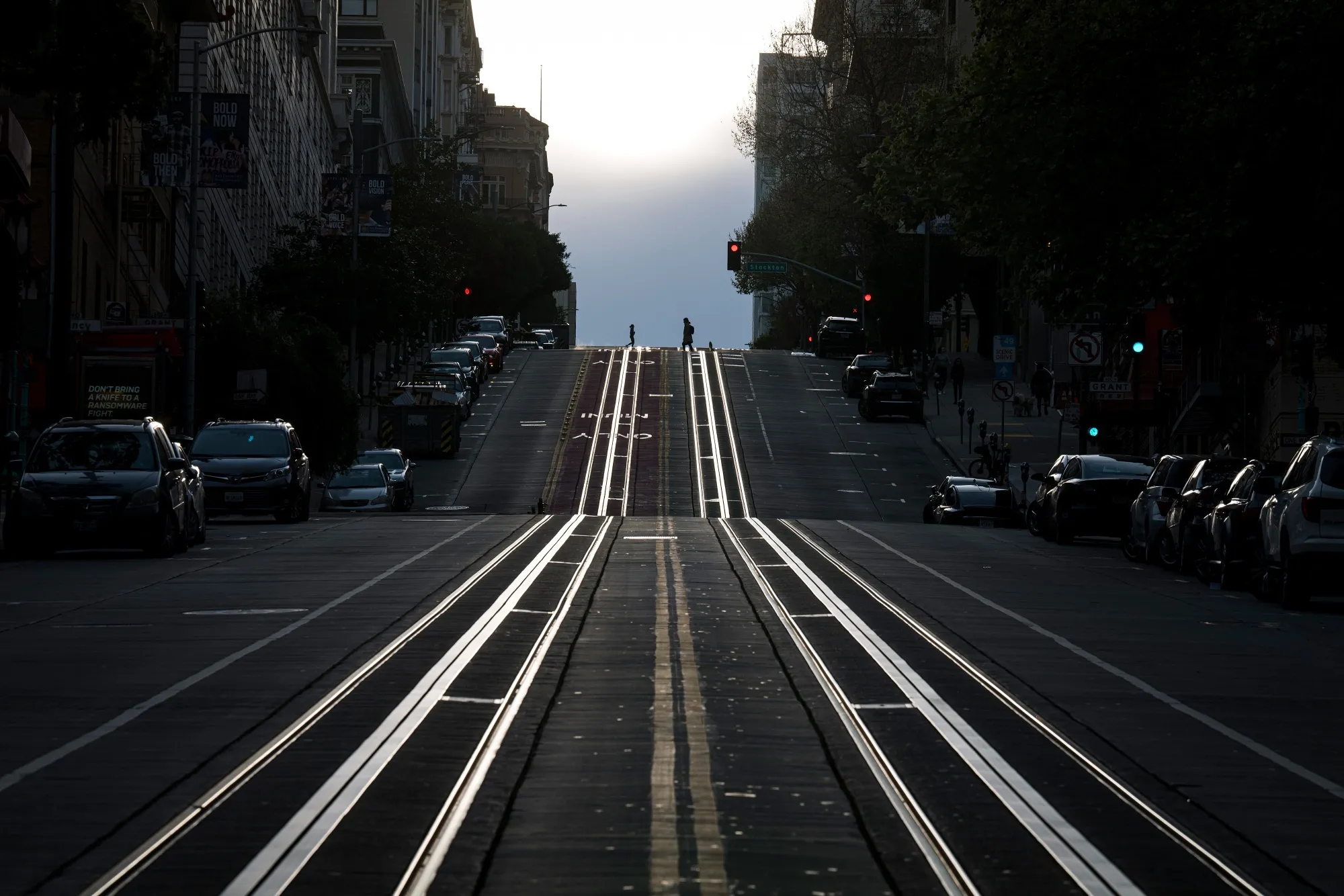 Pedestrians cross an empty California Street in San Francisco, California, U.S., on Tuesday, March 17, 2020. Six of the biggest counties in the San Francisco Bay Area ordered people to stay home except for essential needs, marking one of the nation's strongest local efforts yet to stem the spread of the coronavirus.