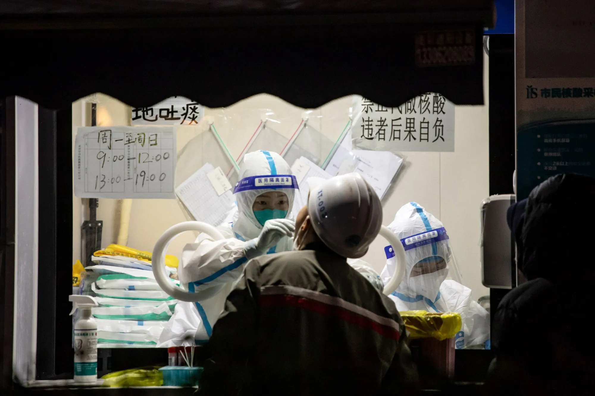 A worker in protective gear swabs a resident at a Covid-19 testing facility in Shanghai, China.