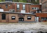 Water from the flooded Jones Falls rushes past offices in Baltimore in April 2014. 