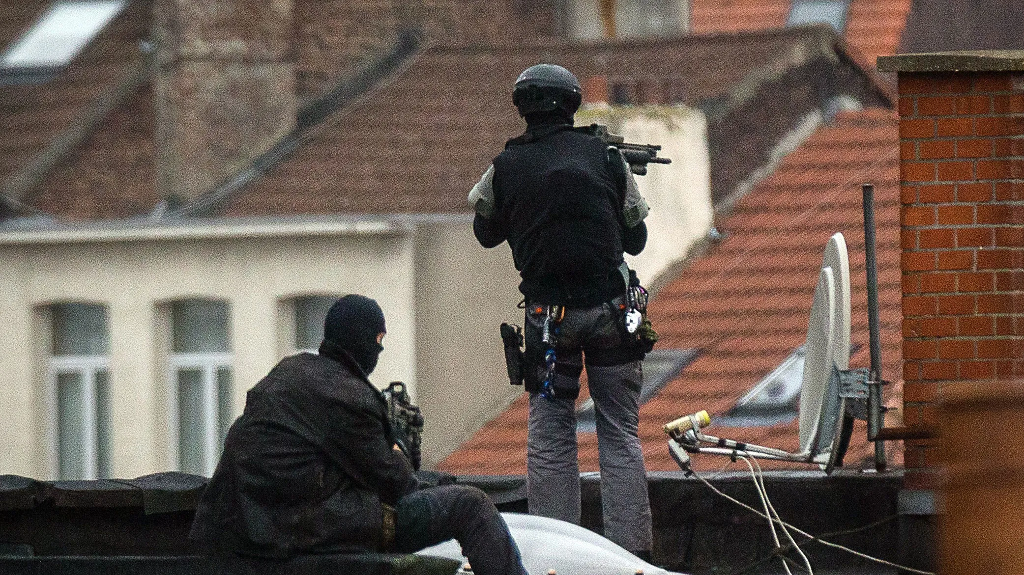 Special force officers stand guard on a roof top in Brussels. Photographer: Dirk Waem/AFP/Getty Images
