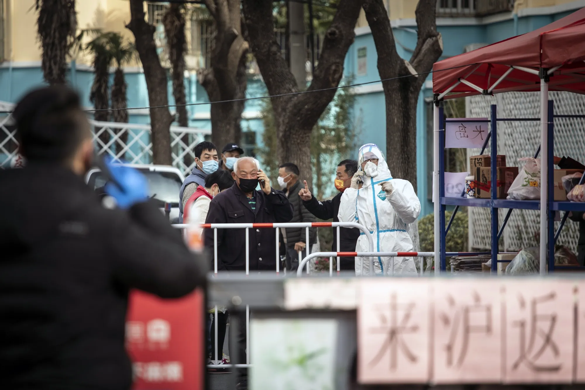 A worker assists residents of a neighborhood placed under lockdown due to Covid-19 in Shanghai, on March 10.