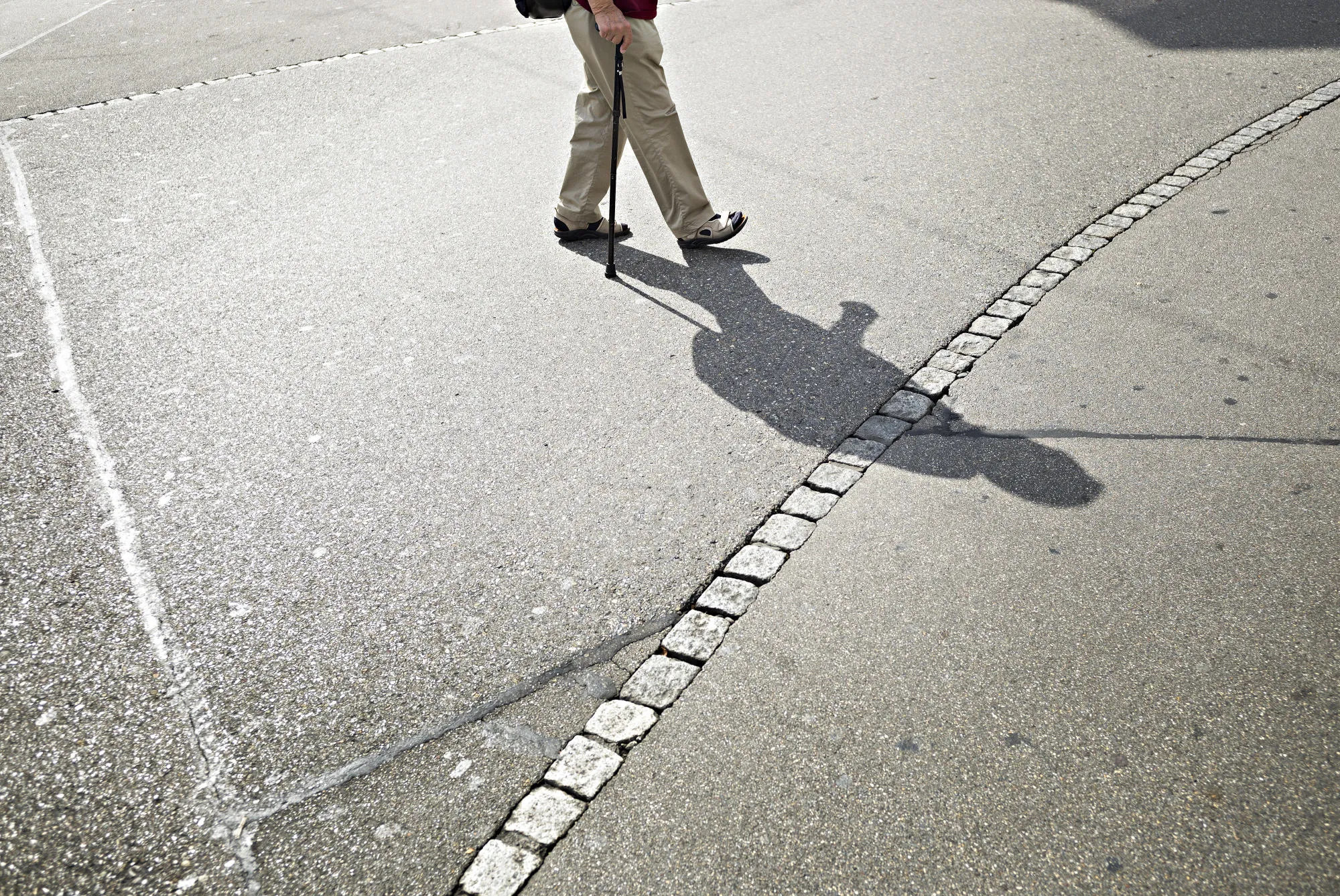 A pensioner walks with the aid of a walking stick in Zurich.