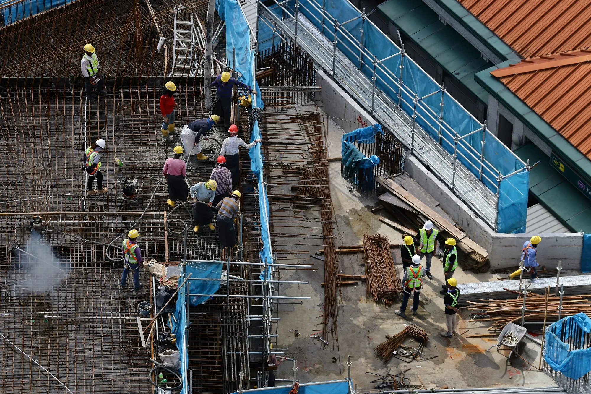 Migrant workers work at a building construction site in&nbsp;Singapore in May.&nbsp;