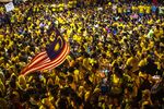 A protester waves the Malaysian Flag around a large crowd gathered around the Dataran Merdeka (Independence Square) during the Coalition for Clean and Fair Elections rally, also known as Bersih, in Kuala Lumpur, Malaysia, on Sunday, Aug. 30, 2015. Malaysian protesters pressed on with the second day of an anti-government rally in the capital, chanting slogans and defiantly wearing the yellow T-shirts that the government had said were banned.
