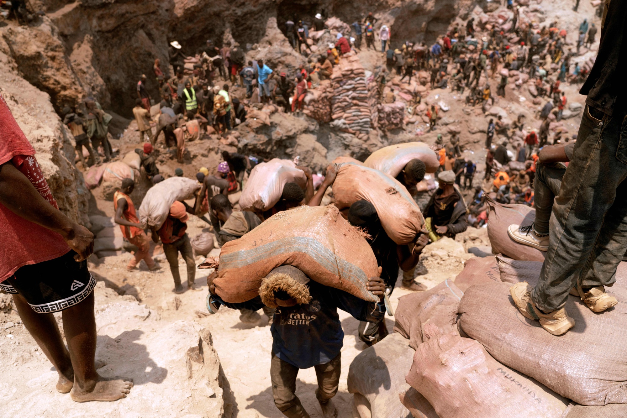 Artisanal miners carry sacks of ore at a cobalt mine near Kolwezi, Democratic Republic of the Congo.