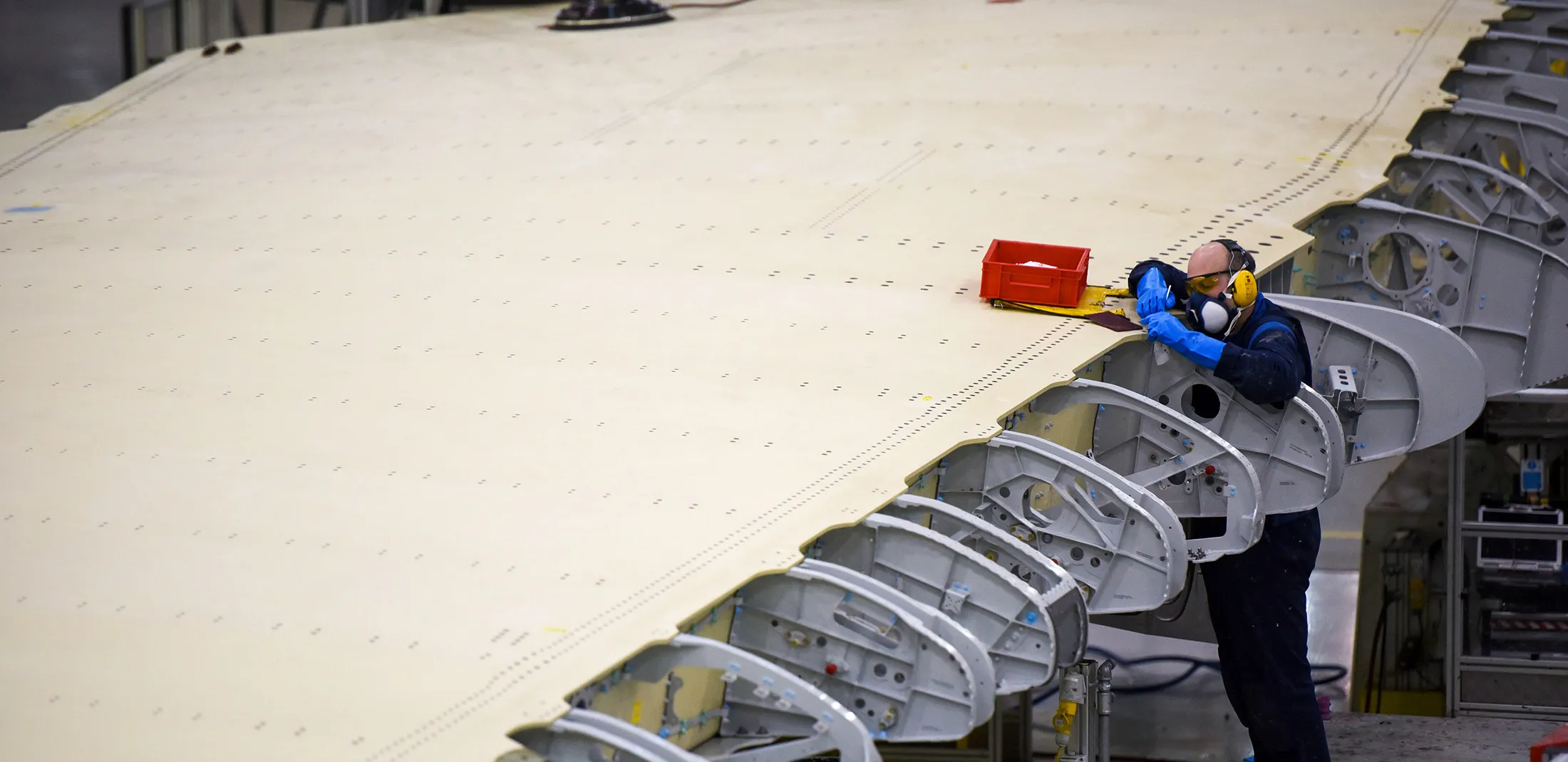An employee works on a section of a wing on the Airbus A350 wing production line at the Airbus SE assembly factory in Broughton, U.K., on Monday, Jan. 16, 2017. Airlines are turning to twin-engine planes like Airbus's A350 and Boeing Co.'s 787 Dreamliner for long routes.
