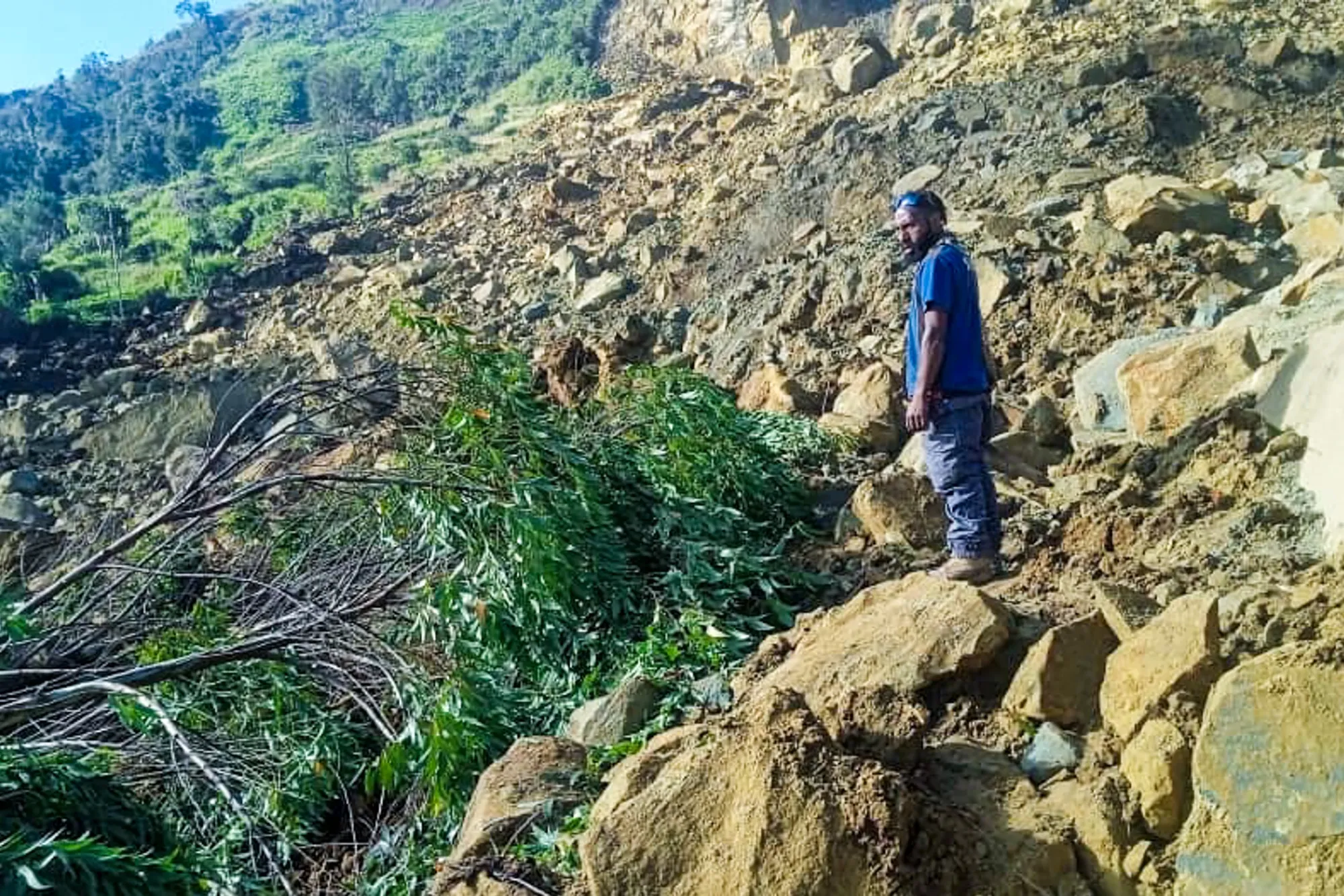 A man stands on rocks at the site of a landslide in Maip Mulitaka in Papua New Guinea’s Enga Province on May 24.