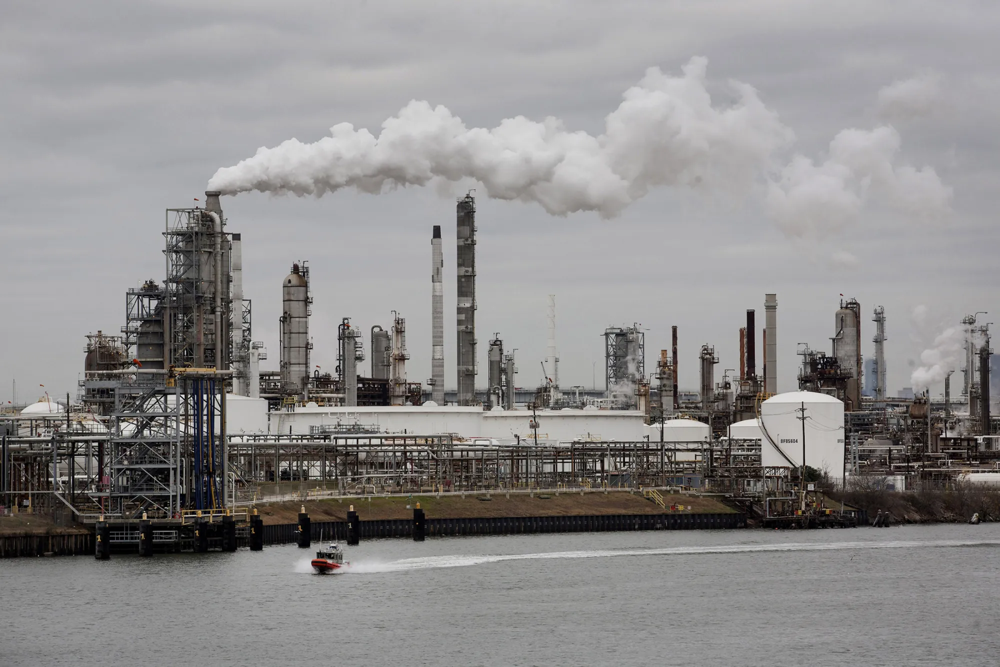 A boat passes a refinery standing along the Houston Ship Channel in Houston, Texas, on Jan. 30, 2014.
