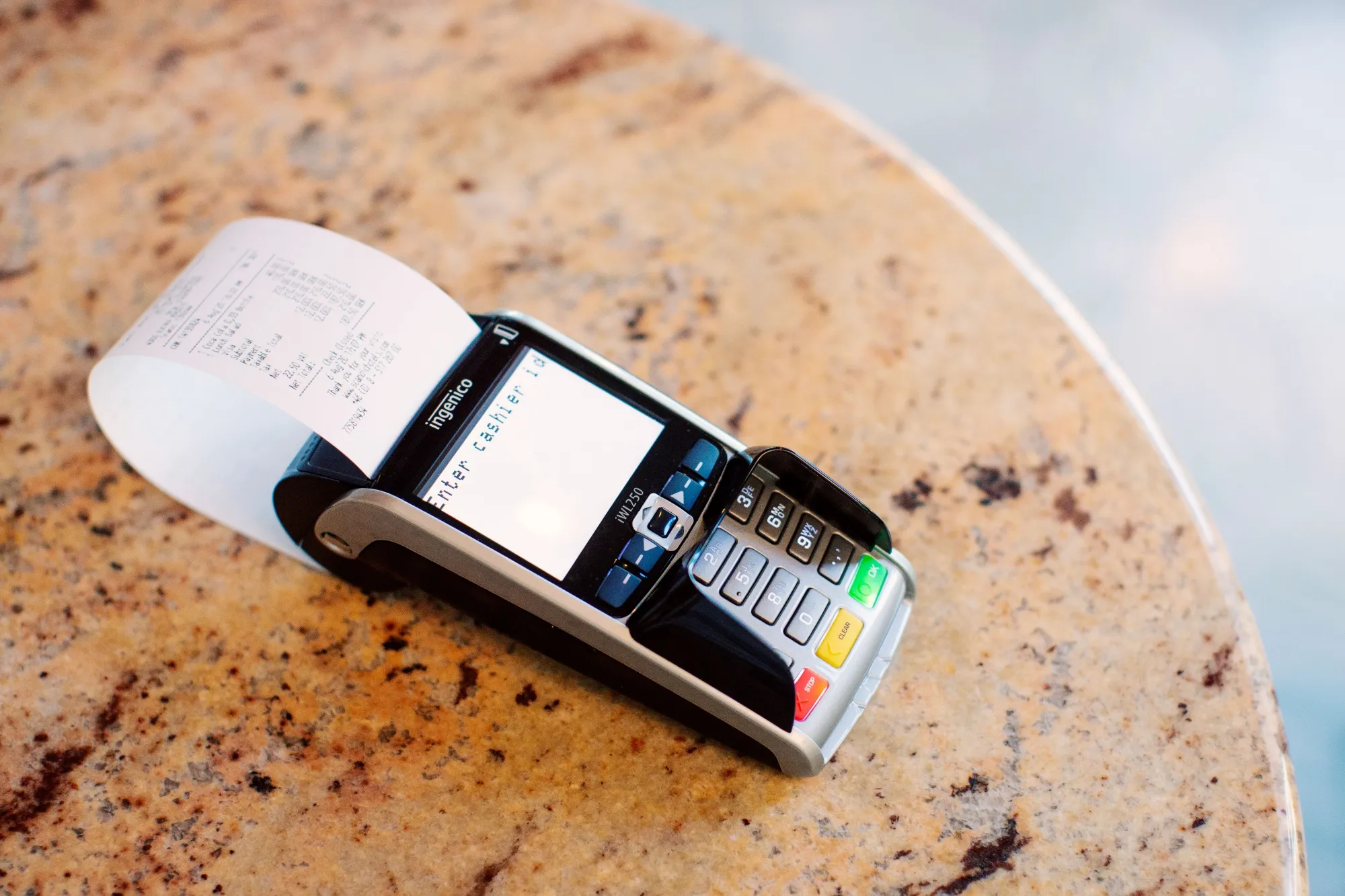 A receipt sits in an Ingenico&nbsp;payment terminal.