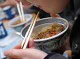 A man eats a bowl of "Gyudon" at a Yoshinoya restaurant duri