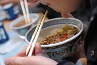 A man eats a bowl of "Gyudon" at a Yoshinoya restaurant duri